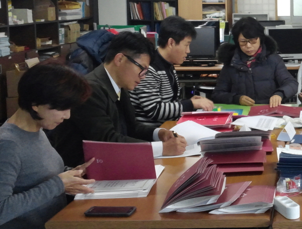 김철호 님(안경 쓴 남자분)이 리스트를 꼼꼼히 점검하고 옆의 보살님이 졸업장을 하나하나 뒤지며 살펴보았습니다.