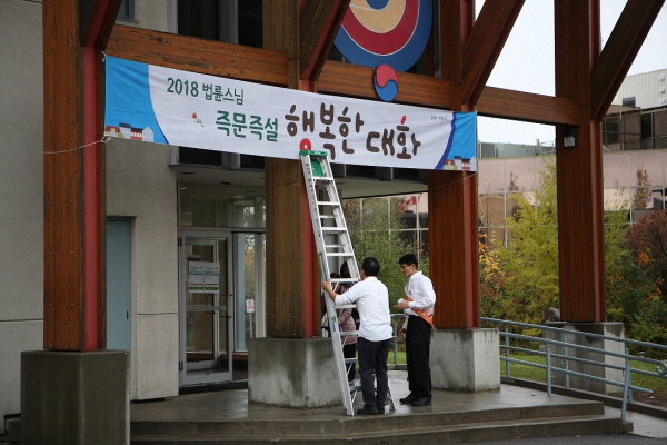 한인회관 입구에 강연 배너를 달고 있는 모습