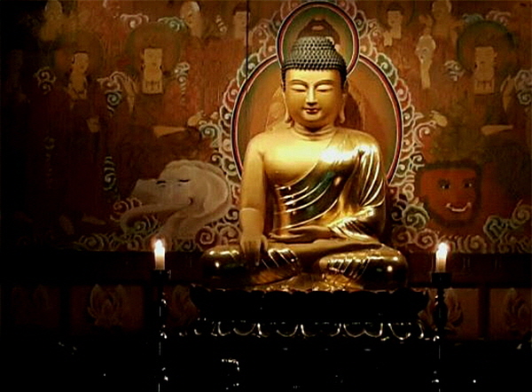  대법당 안, 잔잔한 조명 아래 수행자들을 내려다보고 계신 부처님상.