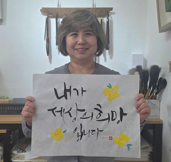 2026년 캘리그라피로 적은 명심문을 들고
