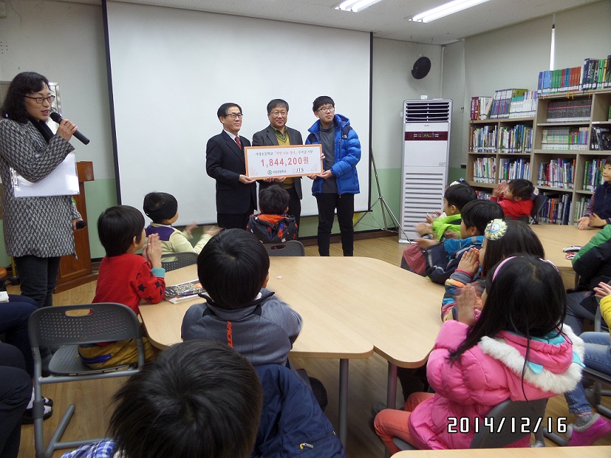 기부금을 전달 받고 있는 JTS 김기진 대표님(왼쪽), 교장선생님(가운데)