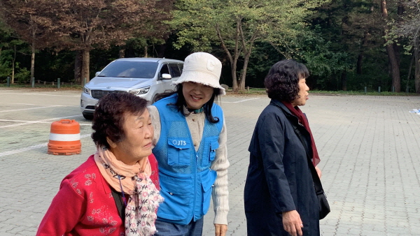 어르신 부축하는 봉사자