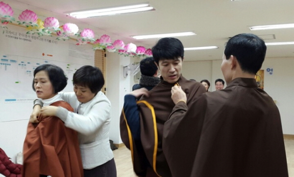 한 사람씩 졸업가운을 입혀주고 있는 총무님과 서로 챙겨주며 준비 중인 경전반 도반들