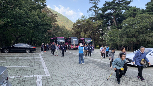 버스에서 내리는 어르신과 봉사자들
