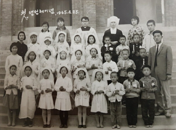 어린 시절 성당에서 (두 번째 줄 오른쪽에서 세 번째))