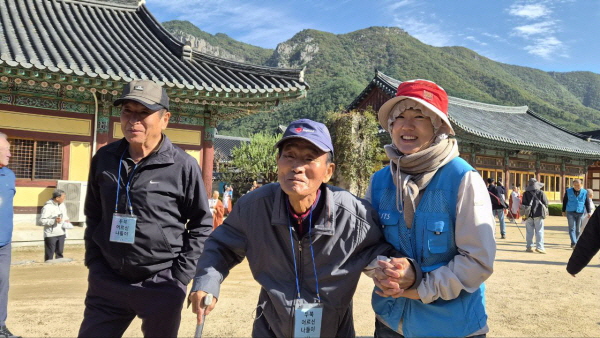 어르신 부축하는 봉사자