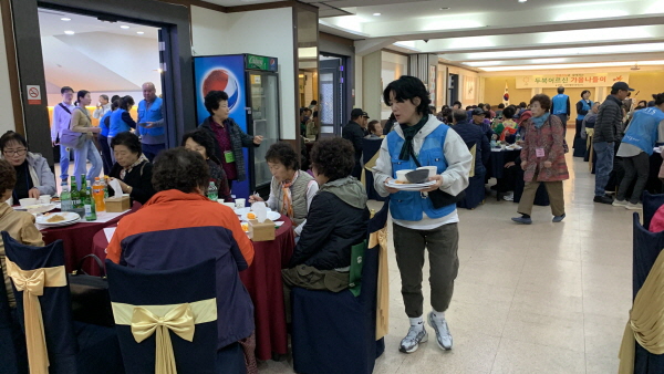 점심을 먹는 어르신들과 봉사 중인 봉사자