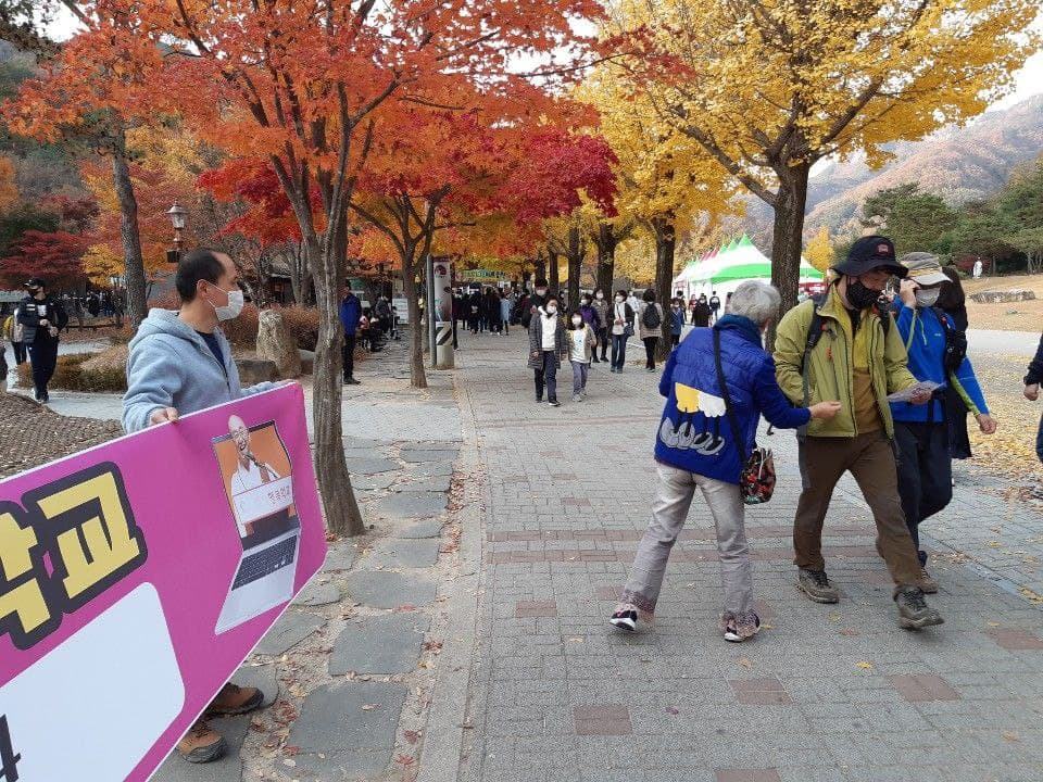 행복학교 홍보중인 주인공의 뒷모습 (중앙 남색 옷)