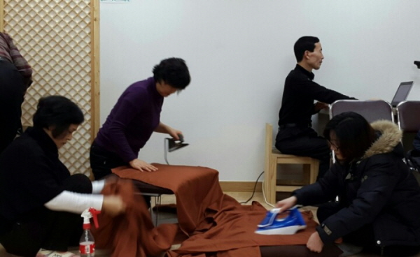 졸업가운 다림질 봉사 중인 윤희옥, 조성아, 한은정 님과 영상 확인 중인 이진규 거사님